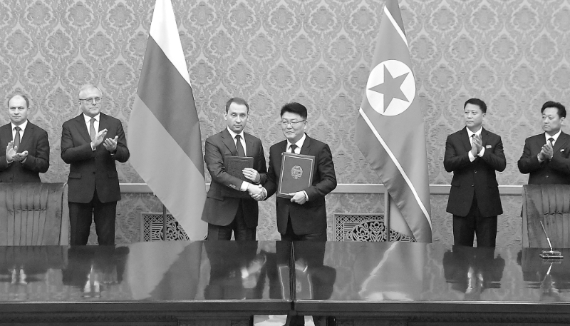 Le ministre russe des ressources naturelles et de l'écologie Alexander Kozlov serre la main du ministre nord-coréen des relations économiques extérieures Yun Jong Ho lors d'une cérémonie de signature à Pyongyang, le 21 novembre 2024.