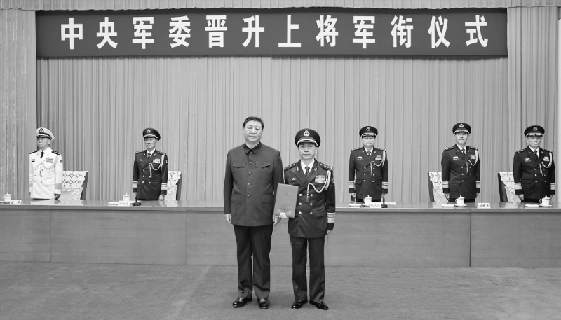 Xi Jinping présente un certificat d'ordre pour promouvoir He Hongjun, directeur exécutif adjoint du département du travail politique de la CMC, au grade de général.